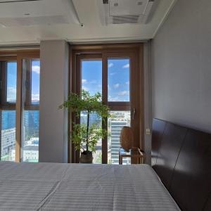 a bedroom with a bed and a large window at 원스테이 가산디지털단지 in Seoul