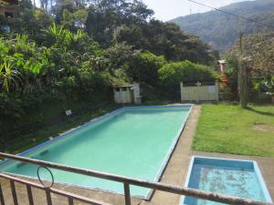 a swimming pool in the backyard of a house at Franklin Hostel & Camping in Coroico