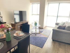 a living room with a table and a couch at Departamento Frente al CC el Polo in Lima