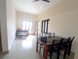 a dining room with a table and some chairs at Eve's Residency in Meppādi