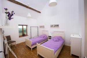 two beds in a room with purple sheets at Villa Souvenir, Lenax in Lenax