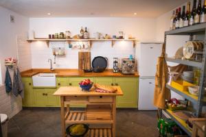 a kitchen with green cabinets and a table with fruit on it at Villa Souvenir, Lenax in Lenax +11 photos