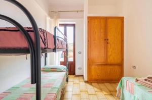 1 Schlafzimmer mit 2 Etagenbetten und einer Holztür in der Unterkunft Casa Alva in Bari Sardo