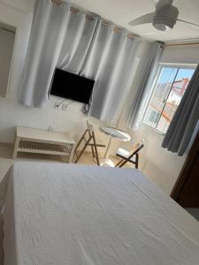 a bedroom with a bed and a window with curtains at Filial Hotel Aconchego da Vila in Saquarema +35 photos