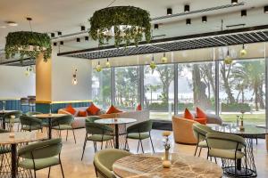 アレクサンドリアにあるRixos Montaza Alexandriaのテーブルと椅子と大きな窓のあるレストラン