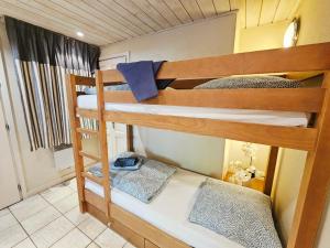 a bedroom with two bunk beds in a room at Appartement Cozy en rez de jardin avec Plage et Parking Privés au Bord du Lac d'Annecy in Duingt