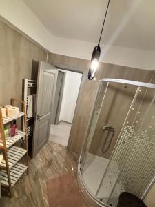 a shower with a glass door in a bathroom at Cozy Nest in Constanţa