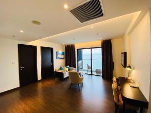 un salon avec un canapé, une table et des chaises dans l'établissement The Sapphire Residence - AloTrip Homes, à Hạ Long