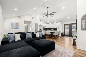 a living room with a black couch and a dining room at Spacious 3BR 3BA Home Modern Renovation in Decatur +18 photos