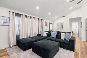 a living room with a black couch and ottoman at Spacious 3BR 3BA Home Modern Renovation in Decatur