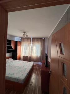 a small bedroom with a bed and a window at Apartament 3 in Drobeta-Turnu Severin