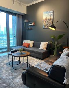 a living room with a couch and a table at Dubai Marina Modern 1 Bedroom Apartment - steps to tram & Marina Walk in Dubai +26 photos
