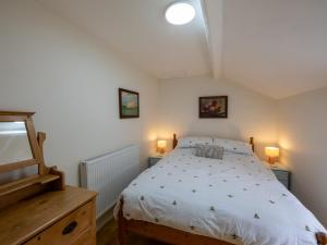 a bedroom with a bed with two lamps on it at Snowdonia Eryri Cottage, Moel Siabod in Dolwyddelan
