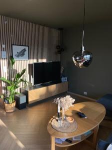a living room with a table and a tv at Nice and modern apartment in Stavanger