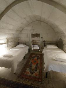 a group of beds in a room with an attic at Cappadocia Masuer House in Ürgüp