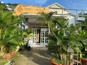 a house with palm trees in front of it at Entire Garden House in Con Dao ! 3BR & 4WC ! Private Yard with Washer & Dryer in Con Dao