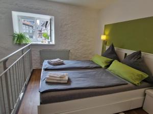 een slaapkamer met een bed met 2 handdoeken en een raam bij Galeriewohnung Ritter Ramm mit kostenlosem Parkplatz und Kamin, Bahnhof fußläufig in Goslar