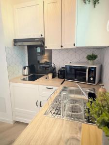 a kitchen with white cabinets and a microwave at Studio Saint-Rémy-de-Provence centre in Saint-Rémy-de-Provence