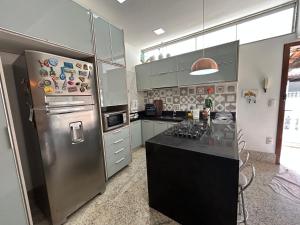 a kitchen with a stainless steel refrigerator and a counter at Raridade Cachoeiro, Apto 2 Qtos, Ar, Ferroviários in Cachoeiro de Itapemirim