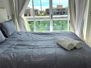 a bed with a towel on it in front of a window at BEACH PARK PALM - COBERTURA Luxo in Aquiraz +94 photos