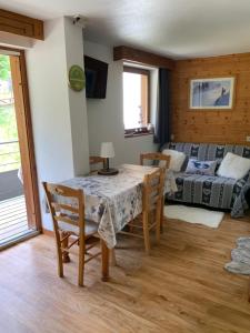 un salon avec une table, des chaises et un canapé dans l'établissement Appartement Chamrousse, à Chamrousse