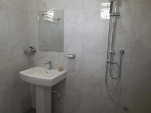 a white bathroom with a sink and a shower at Lodge in Resolute in Dambulla +14 photos