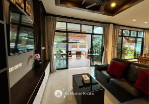 a living room with a couch and a table at Nadia 2 Ao Nang Pool Villa in Ban Chong Phli