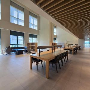 una grande stanza con tavoli e sedie in un edificio di 원스테이 가산디지털단지 a Seul