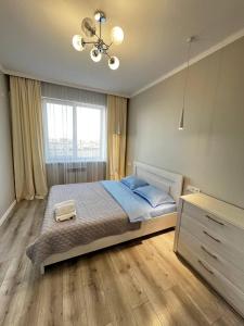 a bedroom with a large bed and a window at In the Center AURUS 2 Room Apart in Almaty