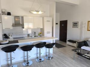uma cozinha com um balcão e bancos num quarto em Apartments Hrvoje em Primošten
