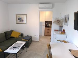 uma sala de estar com um sofá e uma mesa em Apartments Hrvoje em Primošten