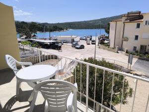 uma varanda com uma mesa e cadeiras e vista para um porto em Apartments Hrvoje em Primošten