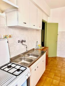 a kitchen with a sink and a stove at Casa del Sogno in Ladispoli