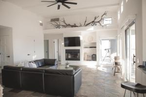 a living room with a leather couch and a tv at Aquarius By The Cohost Company in Yucca Valley