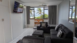 a living room with a couch and chairs at Capri24 - Modern apartment overlooking the sea in Amanzimtoti
