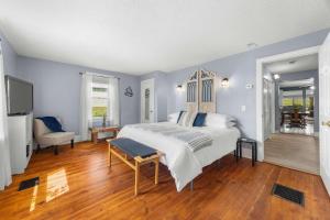 a bedroom with a bed and a television in it at Keuka Wine Trail Vineyard View Farmhouse - Fire Pit & Game Room in Hammondsport