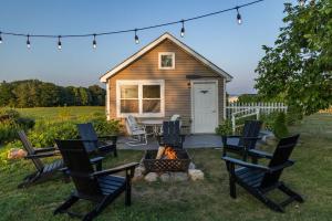 a tiny house with chairs and a fire pit at Keuka Wine Trail Vineyard View Farmhouse - Fire Pit & Game Room in Hammondsport +71 photos