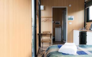 a small room with a bed and a kitchen at Bruce Farm Alpaca Cabin 1 by Tiny Away in Balclutha
