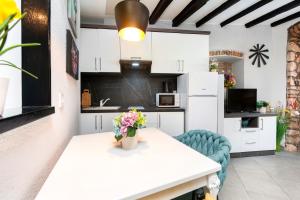 una cocina con armarios blancos y una mesa con flores. en Apartman Tereza, en Rovinj 4 fotos más