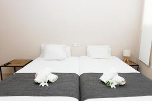 a bedroom with a white bed with towels on it at Apartamento Uso Turistico Ancora de Oro in Fisterra
