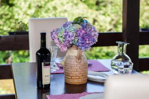 a table with a bottle of wine and a vase of purple flowers at B&B Villa Nena in Plitvica Selo +30 photos