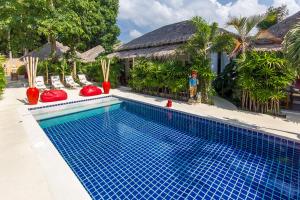 a swimming pool in front of a house at The White Cottage in Bophut 