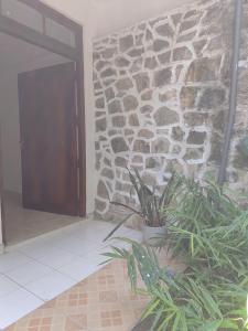 un edificio con una pared de piedra y una puerta en Thenulya Homestay, en Bandarawela