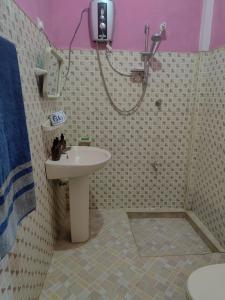 un baño con lavabo y ducha en Thenulya Homestay, en Bandarawela