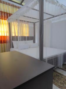 Habitación con cama con almohadas blancas. en Thenulya Homestay, en Bandarawela
