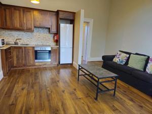 a living room with a couch and a kitchen at Victoria on the Park in Dublin +2 photos