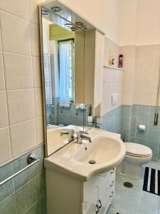 a bathroom with a sink and a toilet and a mirror at Casa del Sogno in Ladispoli +7 photos