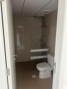a small bathroom with a toilet and a shower at Sea and lake view apartment in Muscat