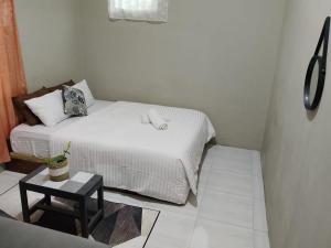 a small bedroom with a bed and a table at Surya homestay in Batukaras