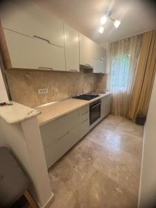 a kitchen with white cabinets and a stove top oven at Ywa in Râmnicu Vâlcea